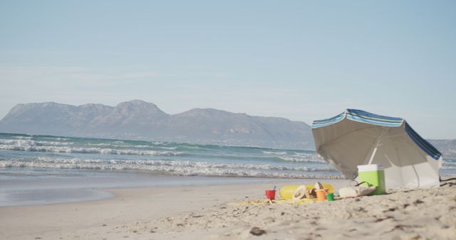 Abandoned Beach Setup with Umbrella, Cooler and Toys by the Seaside - Download Free Stock Images Pikwizard.com