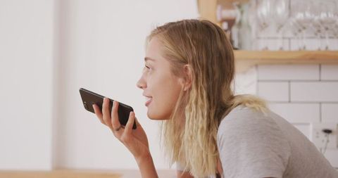 Woman Relaxing in Kitchen Talking on Smartphone