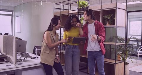 Collaborative Team Discussing Project on Tablet in Stylish Office