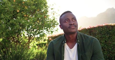 Contemplative african american man relaxing in sunlit garden backlit portrait for wellness