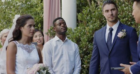 Happy mixed-ethnic couple during romantic outdoor wedding ceremony