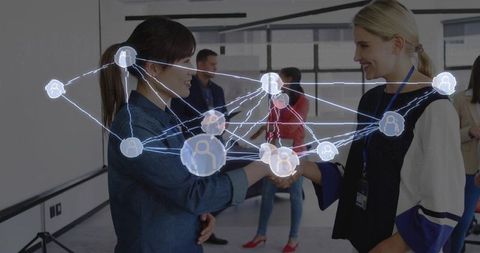 Businesswomen Shaking Hands with Digital Network Overlay