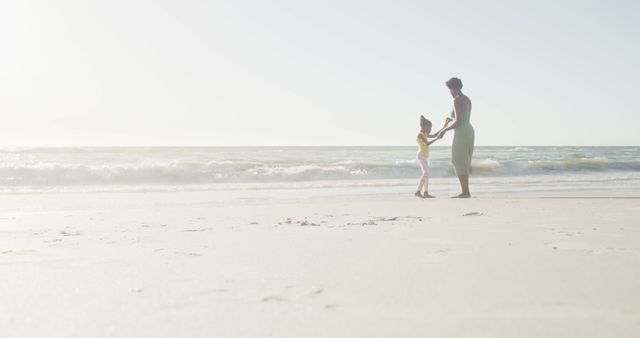 Mother and Daughter Playing on Sunlit Beach - Download Free Stock Images Pikwizard.com