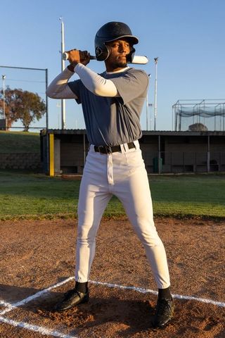 African American Baseball Player Standing in Batter's Box Holding Bat During Golden Hour