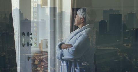 Elderly Woman Contemplating Cityscape Through Window