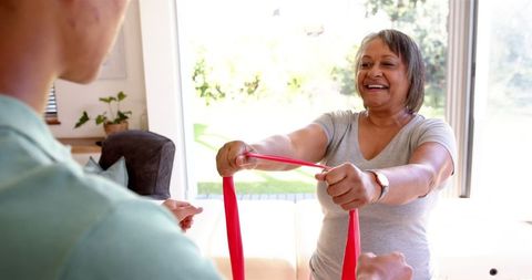 Senior woman exercising with resistance band in therapy session