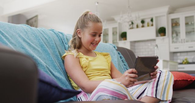 Happy Young Girl Watching Tablet at Home on Couch with Smiling Expression - Download Free Stock Images Pikwizard.com