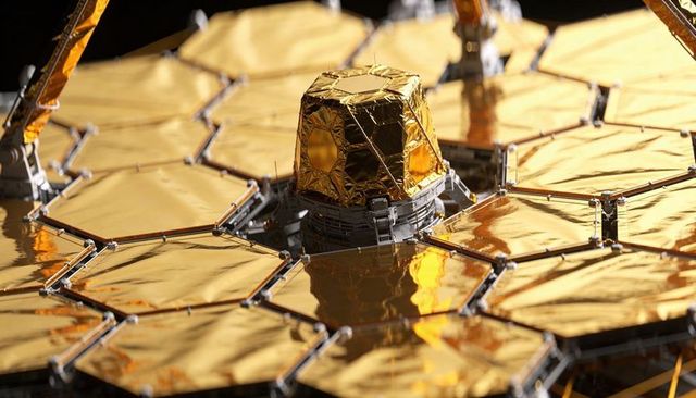 Gleaming gold hex mirrors reflecting lab lights on segmented space telescope primary mirror