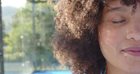 Sunlit african american woman enjoying poolside moment with natural curly hair