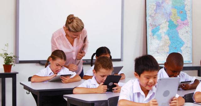 Children Using Tablets During a Classroom Activity with Teacher Assistance - Download Free Stock Images Pikwizard.com