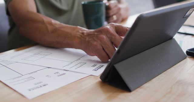 Person Using Tablet for Paperwork and Coffee on Desk - Download Free Stock Images Pikwizard.com