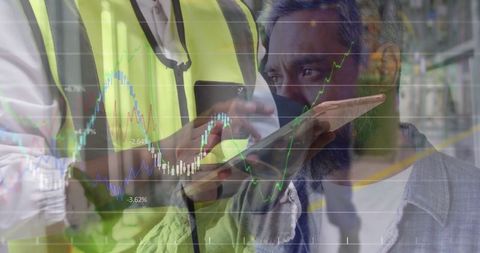 Industrial workers analyzing data with technology in dynamic warehouse environment