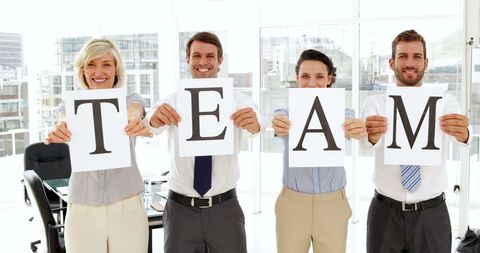 Business Team Holding Signs Forming Word TEAM in Office - Download Free Stock Images Pikwizard.com