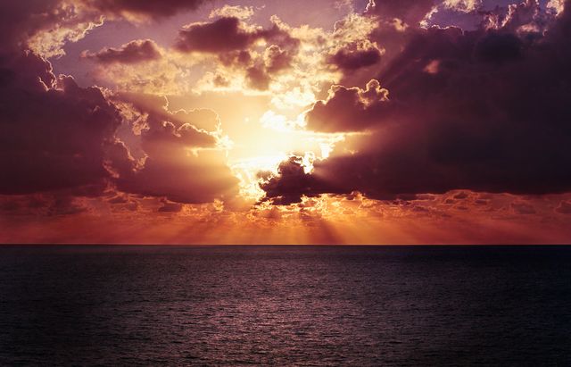 Dramatic sunset over ocean with clouds and sunlight rays - Download Free Stock Photos Pikwizard.com