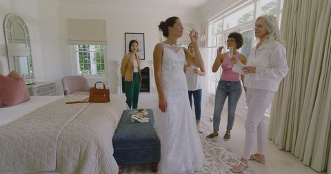Bride Celebrating with Friends Toasting Champagne in Bedroom