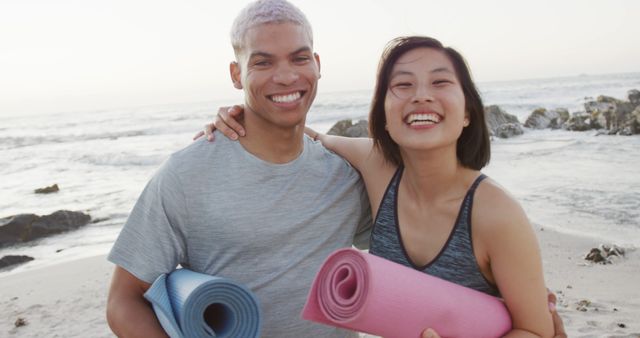 Smiling Couple Holding Yoga Mats on Beach at Sunrise - Download Free Stock Images Pikwizard.com