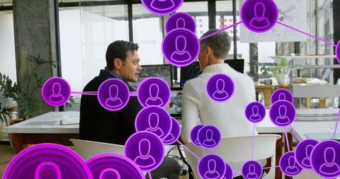 Diverse coworkers in office with networking icons overlay