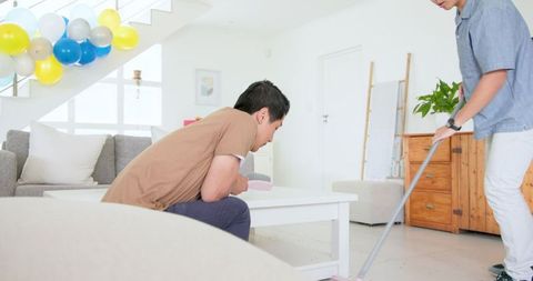 Father and son tidying up confetti after celebration