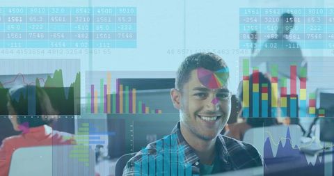 Smiling young professional analyzing colorful data visualizations in open-plan office