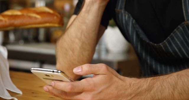Man in Apron Using Smartphone While Working at Bakery Counter - Download Free Stock Images Pikwizard.com