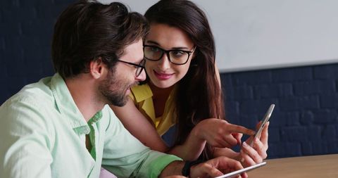 Colleagues Collaborating on Smartphone at Modern Office