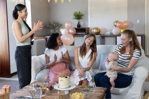 Diverse Group of Female Friends Celebrating with Cake and Posing Baby