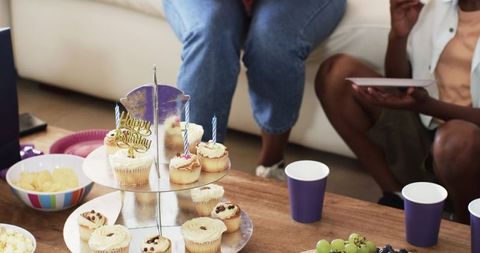 African American Couple Celebrating Birthday at Home with Cupcakes and Party Snacks