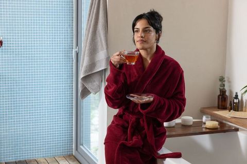 Woman Relaxing with Tea in Luxurious Bathroom Comfort