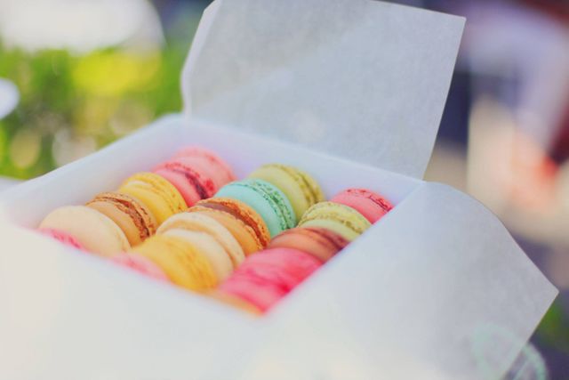 Assorted macarons in vibrant colors displayed in an open box. The image highlights the appealing look of these popular French desserts, making it perfect for use in food blogs, culinary websites, advertisements for bakeries or patisseries, and gourmet food packaging designs.