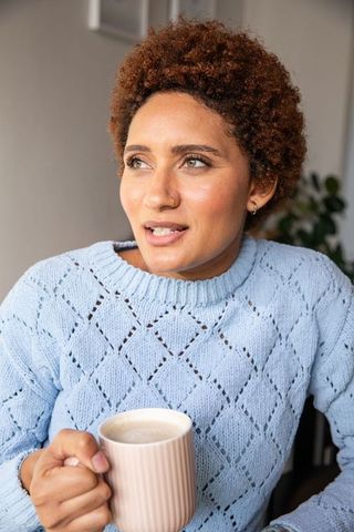 Thoughtful African American Woman Enjoying Coffee at Home
