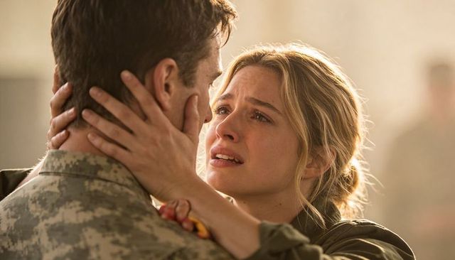 Tearful homecoming woman holding soldier's face during emotional military reunion