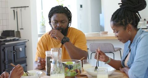 African family sharing healthy meal at sunlit modern kitchen table