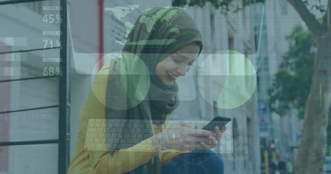 Woman in hijab analyzing financial data on smartphone