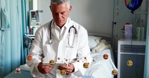 Doctor reviewing medical records with tablet in hospital room