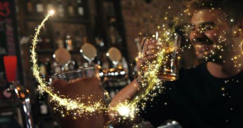 Smiling man toasting with beer at cozy pub bar with golden sparkle overlay