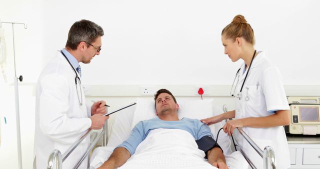 Doctors Consulting with Patient Lying in Hospital Bed - Download Free Stock Images Pikwizard.com