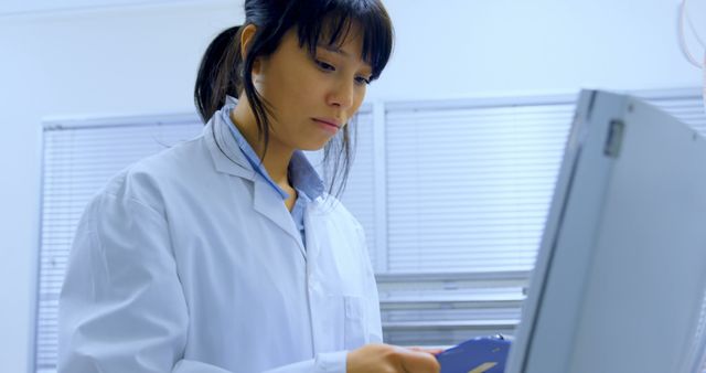 Biracial female scientist checking blood samples by computer in blood laboratory with copy space - Download Free Stock Photos Pikwizard.com