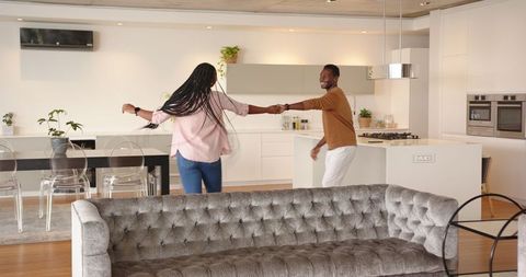 Joyful couple dancing in contemporary minimalist kitchen