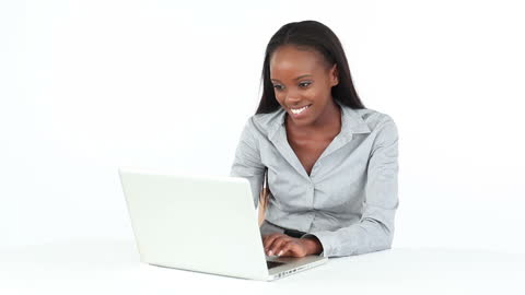 Smiling Woman Using Laptop at Desk