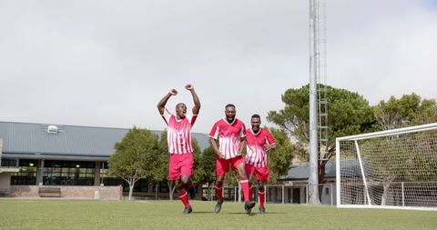 Excited Soccer Players Celebrating on Field in Joyous Victory Moment