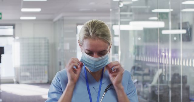 Healthcare Worker Adjusting Face Mask in Hospital Setting - Download Free Stock Images Pikwizard.com