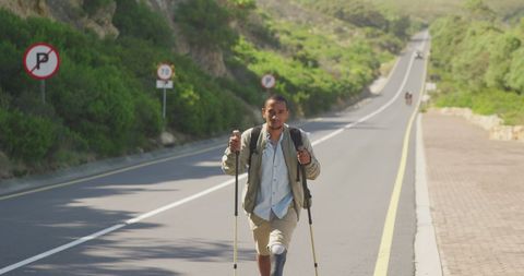 Active Hiker with Prosthetic Leg Walking on Scenic Mountain Road