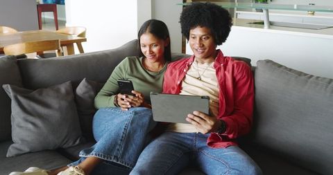 Diverse Couple Enjoying Technology on Cozy Couch