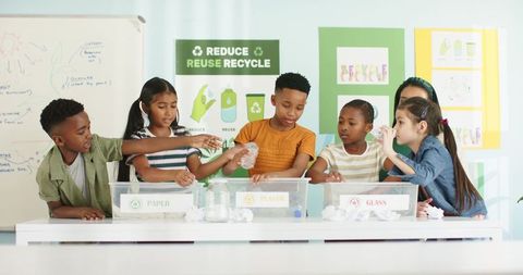 Elementary students sorting recyclables in colorful classroom during hands-on environmental lesson