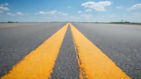 Low-Angle Push-In Tracking Shot Along Yellow Double Centerline Leading to Horizon