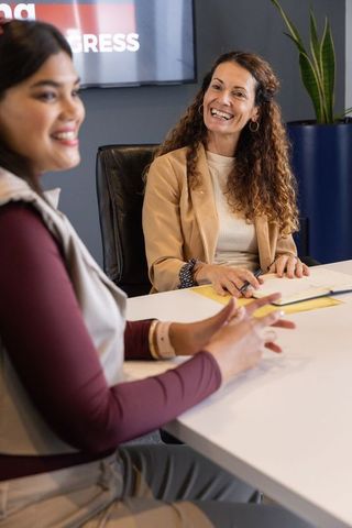 Smiling colleagues collaborating over documents in modern office boardroom at team meeting