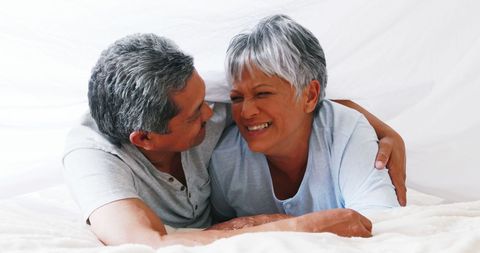 Senior Couple Enjoying Cherished Time Together Hugging and Lying in Bed