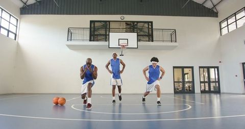 Basketball Team Training with Lunges on Indoor Court