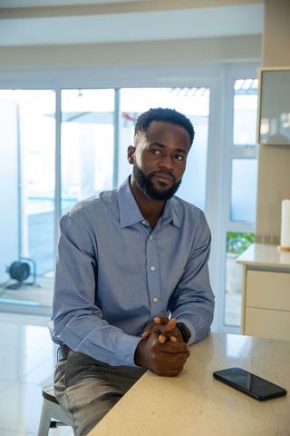 Mid Adult Man Relaxing Contemplatively in Modern Kitchen