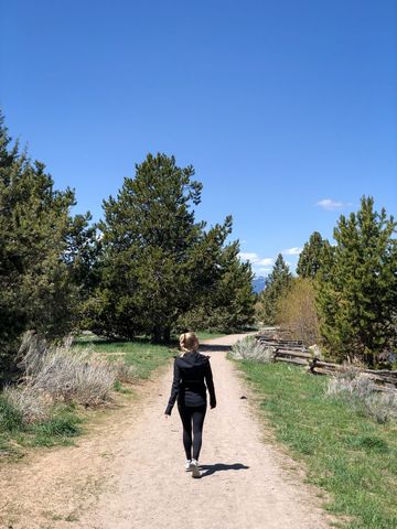 Woman Walking on Trail in Scenic Forested Area